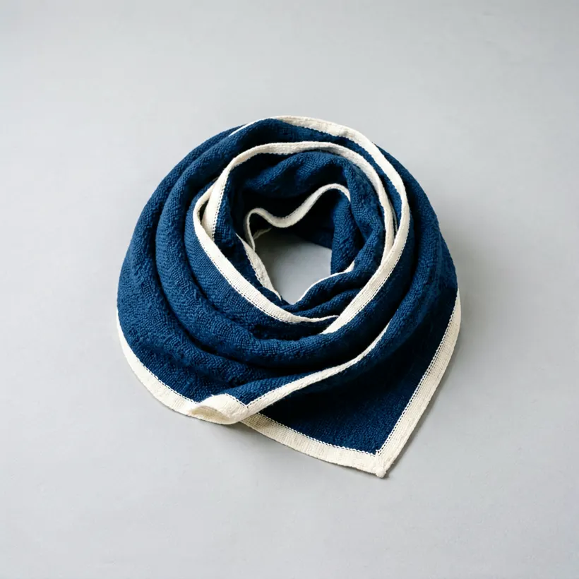 A deep indigo handwoven cotton stole loosely coiled