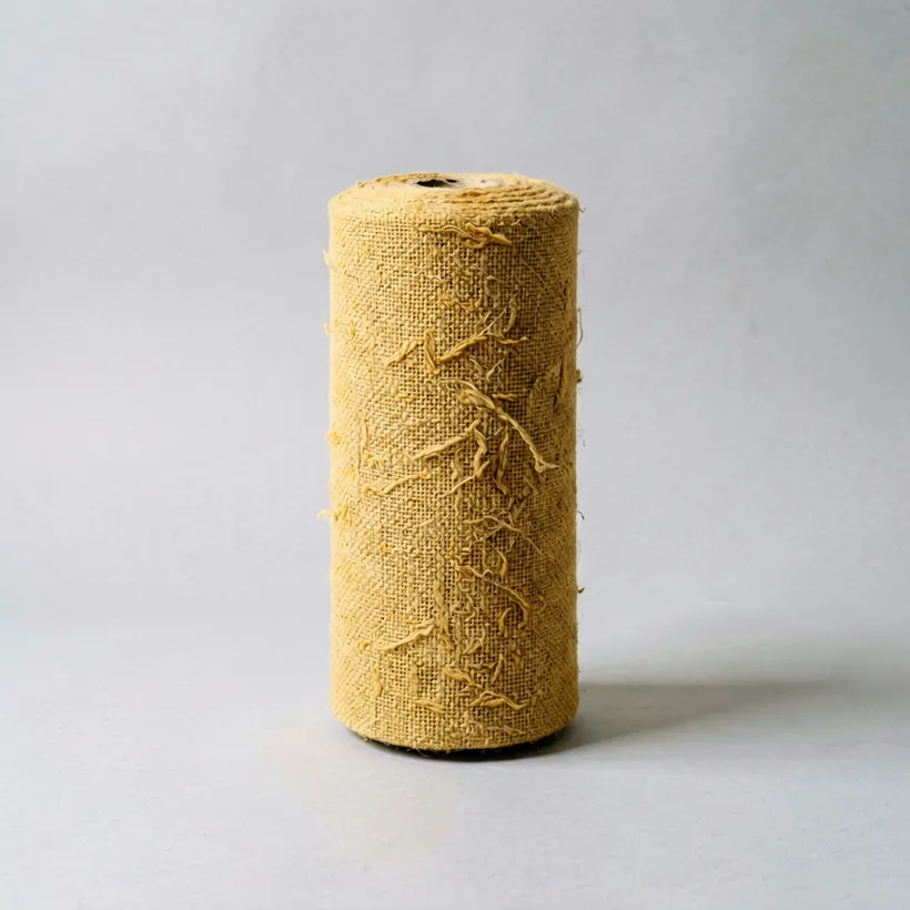 A rolled bolt of handwoven cotton yardage in soft ochre with slubbed texture